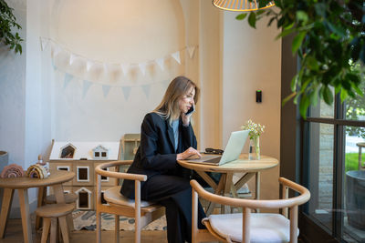 Portrait of young woman using digital tablet while sitting at home