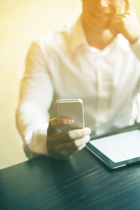 Midsection of man using mobile phone