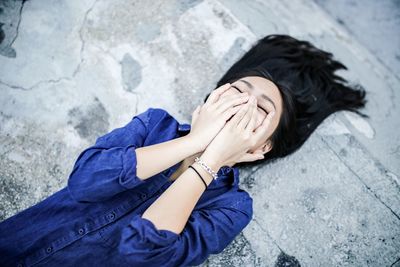 High angle view of woman lying on ground and smiling