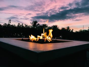 Close-up of bonfire against sky at sunset