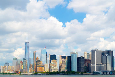 One world trade center in city against cloudy sky