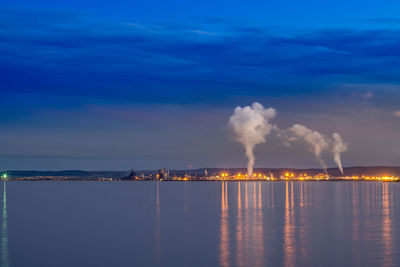 Smoke emitting from factory against sky