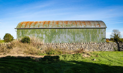 Built structure on field against sky