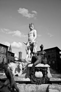 Low angle view of statue against building against sky