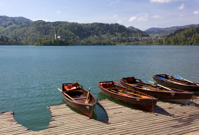 Boats moored on lake against sky