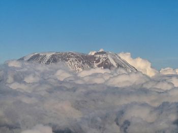 Scenic view of snowcapped mountains against blue sky