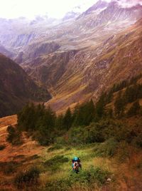 High angle view of woman hiking on field against mountains