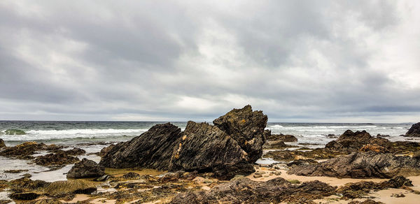 Rocks on beach against sky