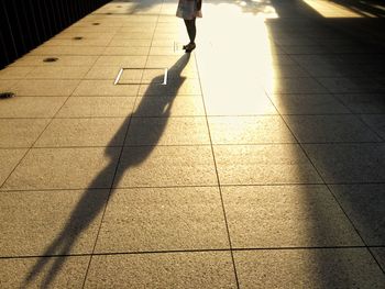 Low section of woman walking on road