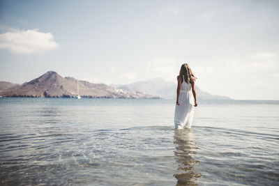 Man standing on cliff by sea