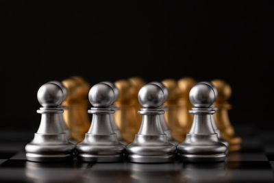 Close-up of chess pieces against black background