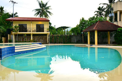 Swimming pool by building against sky