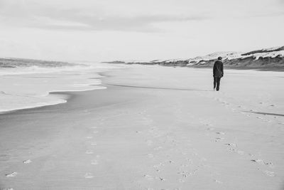 Rear view of man walking on beach
