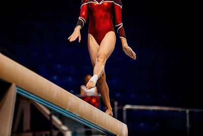 Low section of gymnast standing on wooden plank