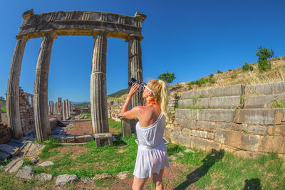 Full length rear view of woman standing against clear sky