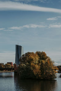 Scenic view of river by buildings against sky