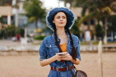 Portrait of young woman standing on road