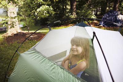 Portrait of smiling girl sitting in tent