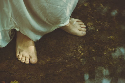 Low section of person standing in water