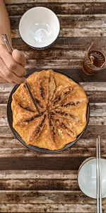 High angle view of hand holding bread on table