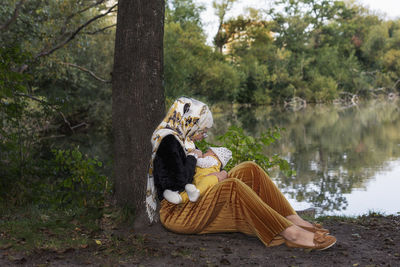 Mother breastfeeding baby at lake