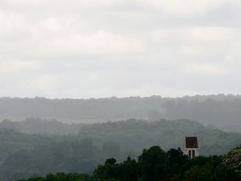 Trees on landscape against sky