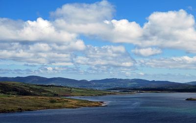 Scenic view of sea and mountains against sky