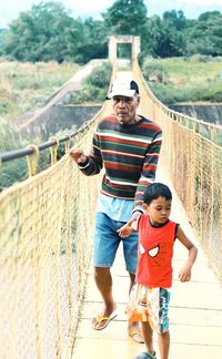 Full length of father and daughter on footbridge