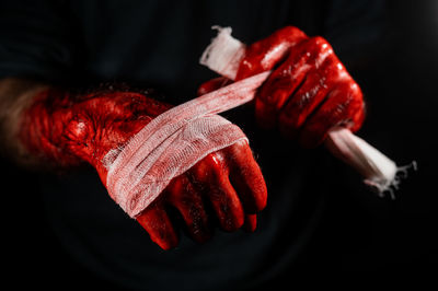 Man with bloody hands using a bandage