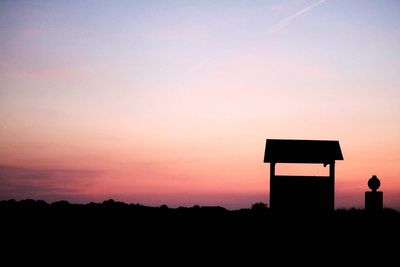 Silhouette built structure against sky at sunset