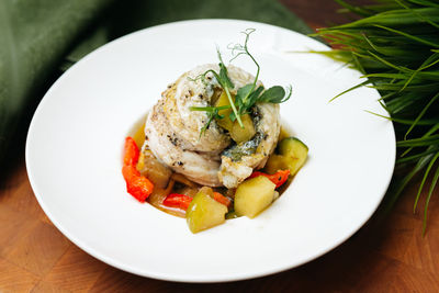 Baked sea bass fillet with chopped apples, red sweet pepper, and zucchini.