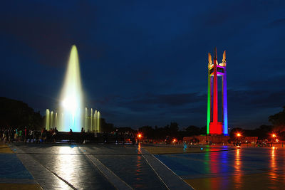 Illuminated fountain against sky at night