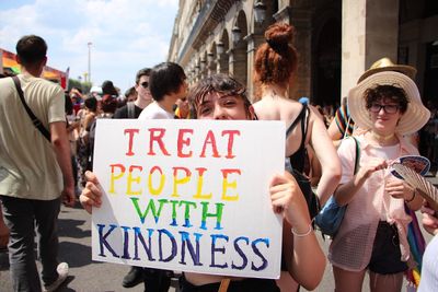 Woman holding placard with text during protest in city