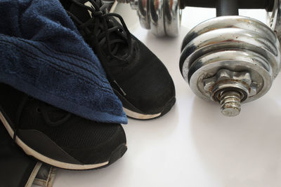 High angle view of sports shoe with dumbbell on floor