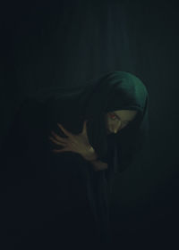 Portrait of woman against black background
