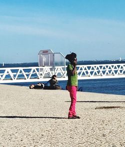 Girl standing on bridge against sky