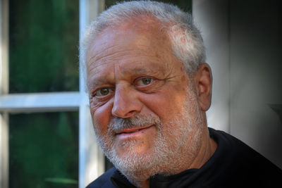 Outdoor portrait of mature man with window.