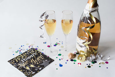 Two glasses and bottle of champagne against white background.