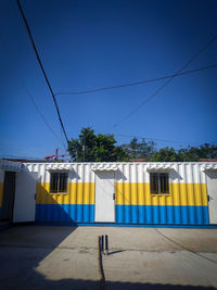 Yellow flag on building against clear blue sky