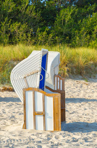 Empty chair on sand at beach