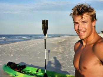 Millennial handsome guy ready to go fishing in kayak.