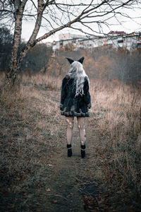 Rear view of woman walking in forest
