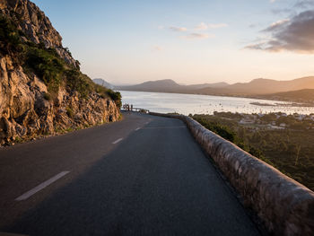 Scenic view of road by sea against sky