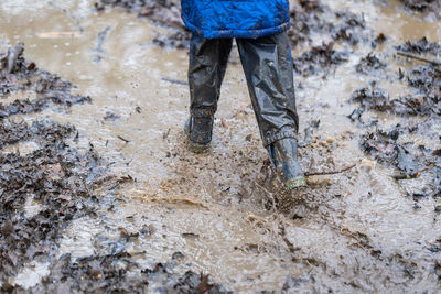 Low section of man standing in mud