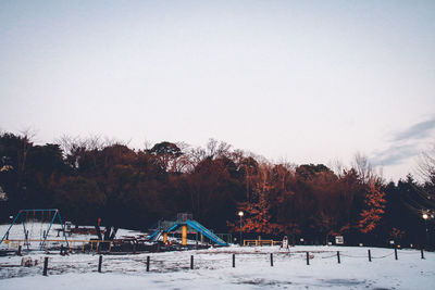 Snow covered playground against sky