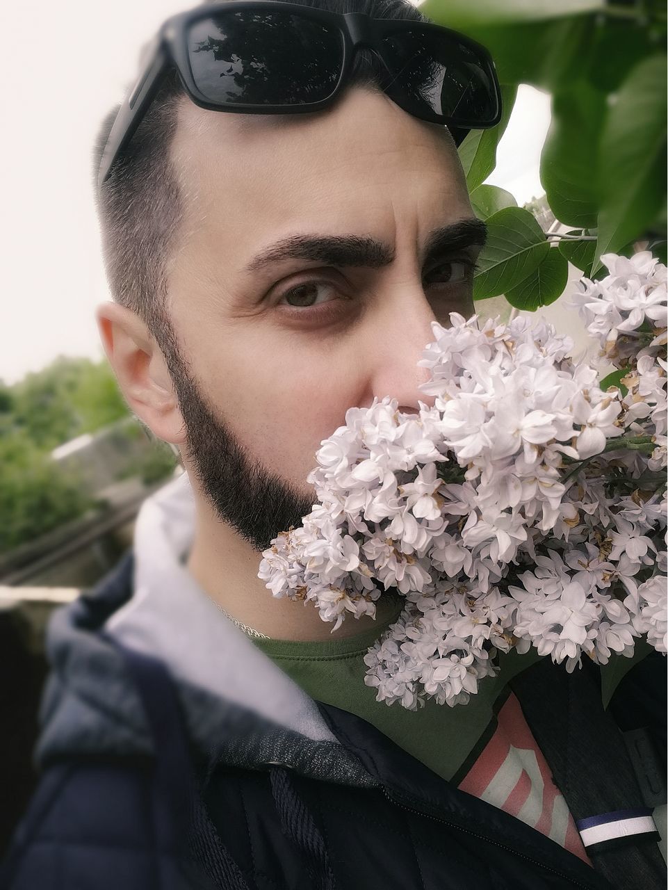 portrait, real people, one person, headshot, plant, leisure activity, young adult, lifestyles, young men, flower, close-up, men, flowering plant, front view, nature, looking at camera, vulnerability, beard, flower head, outdoors, human face