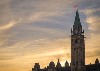 Low angle view of the peace tower in ottawa against sky during sunset