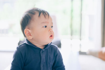 Portrait of cute boy looking away at home