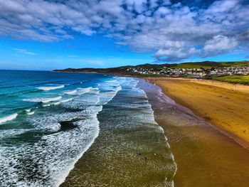 Scenic view of beach against cloudy sky