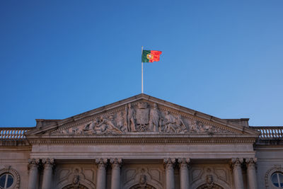 Low angle view of flag against clear blue sky